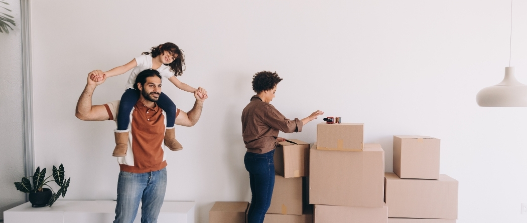 little girl on dad's shoulders as they are moving into a new home