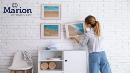lady hanging picture on the wall