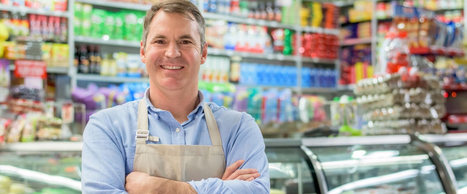 Grocery store owner standing in the deli
