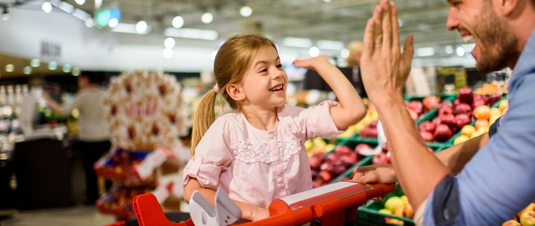 Little girl high fiving dad in the grocery store