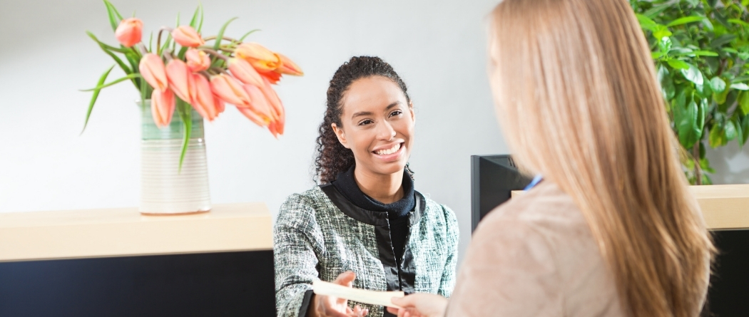 Teller handing lady deposit slip
