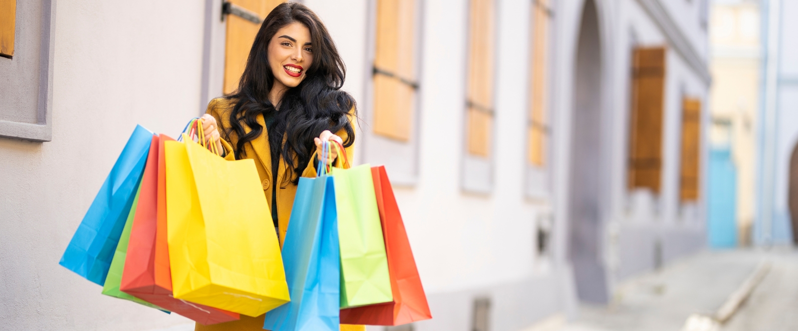 woman holding brightly colored shopping bags