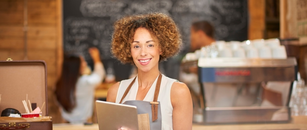 Server in an apron holding a tablet