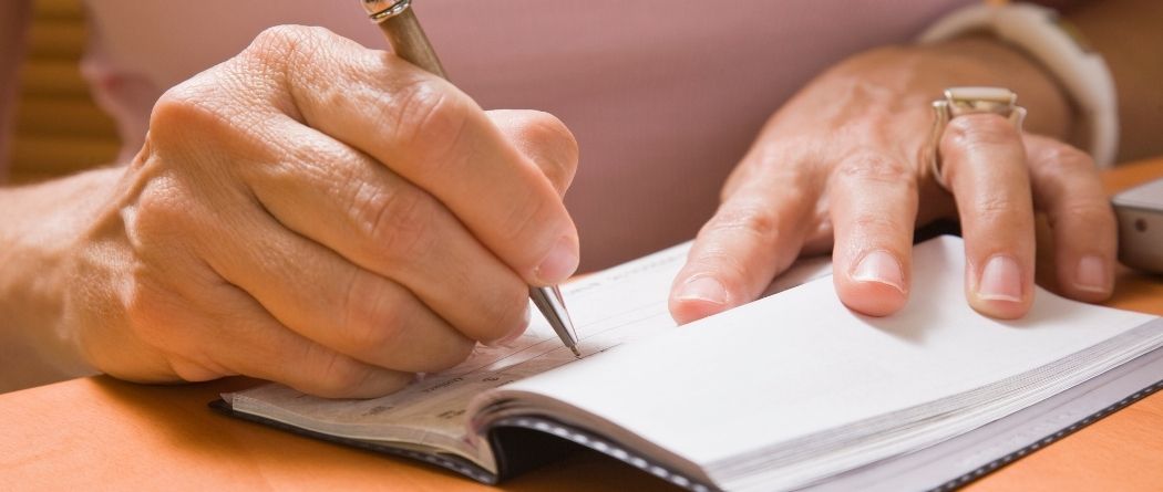 a hand writing a check
