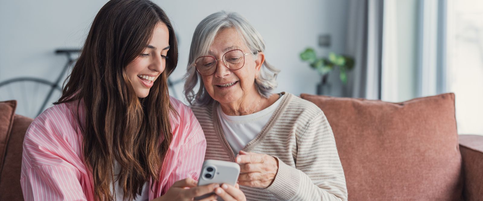 Young girl showing elderly lady something on a mobile phone