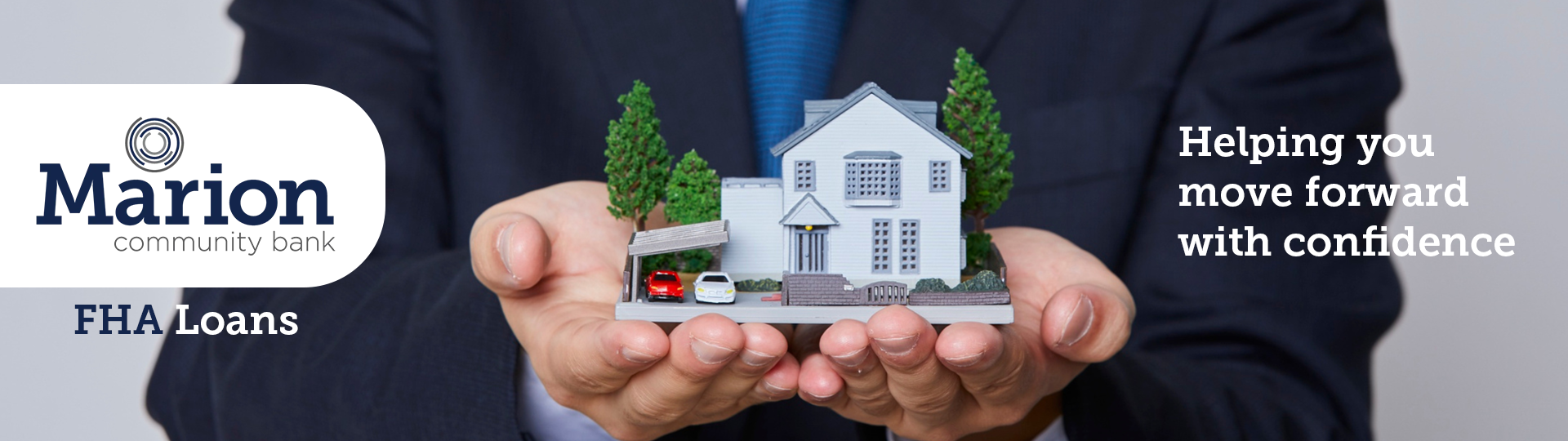 Image of a small house being held up by a loan agent. Overlaying text reads: Marion Community Bank FHA Loans and Helping You Move Forward with Confidence