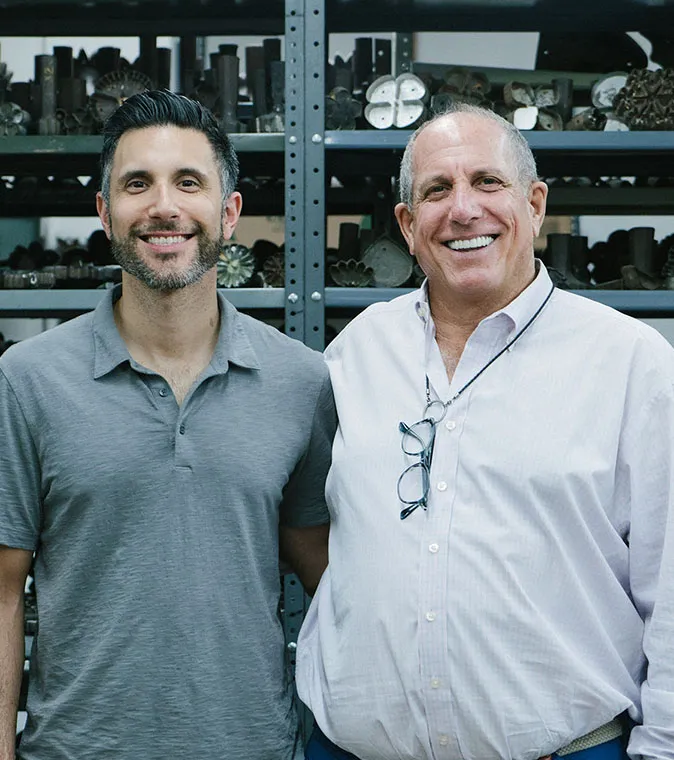 Two business owners smiling at the camera.