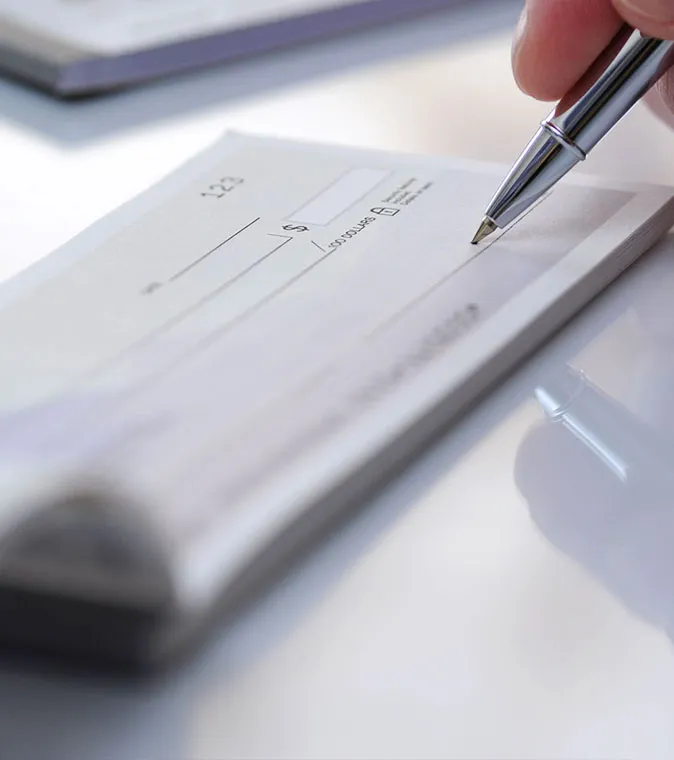 Image of someone writing out a check.