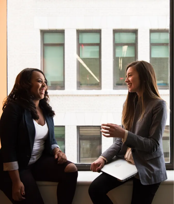 Two women talking in a bank lobby.