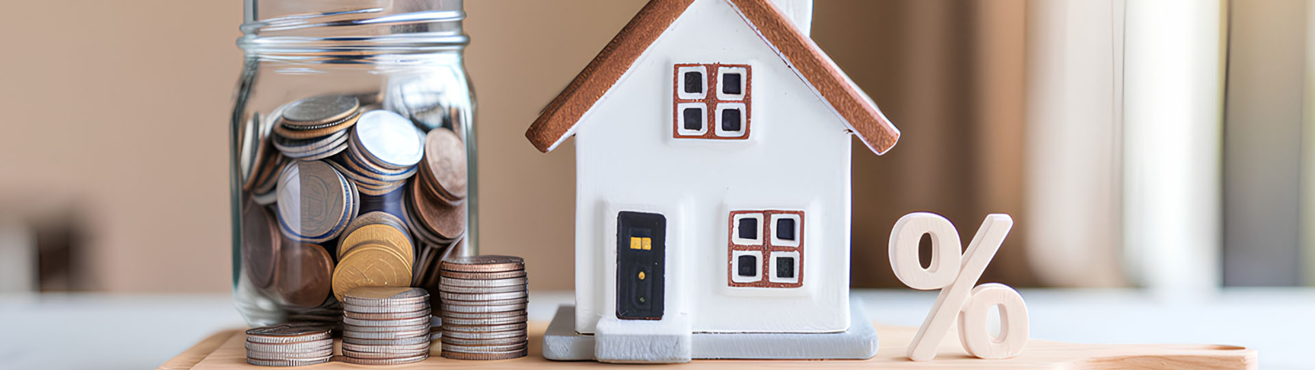 Toy house beside a jar of coins.