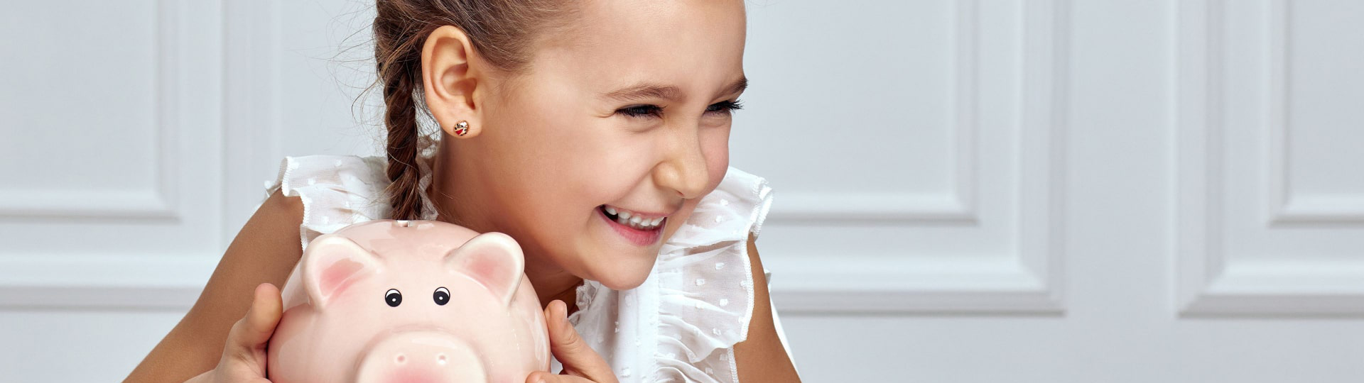 Young child placing coin in piggy bank