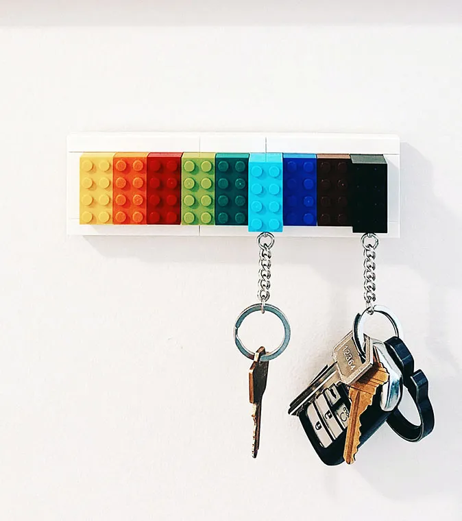Keys hanging from a wall rack made of legos.